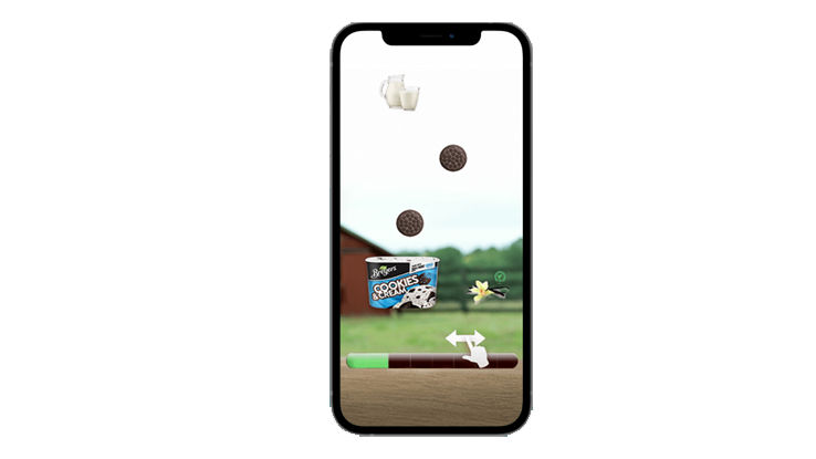 "Mobile phone displaying a playable ad for cookies and cream ice cream, featuring interactive elements such as moving cookies, milk, and an ice cream tub with a progress bar at the bottom."