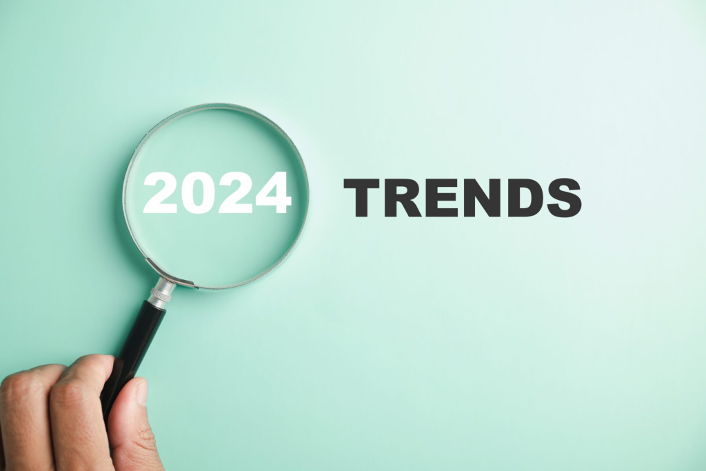 A magnifying glass focusing on the text '2024' next to the word 'TRENDS,' symbolizing the examination and exploration of upcoming trends for the year 2024.